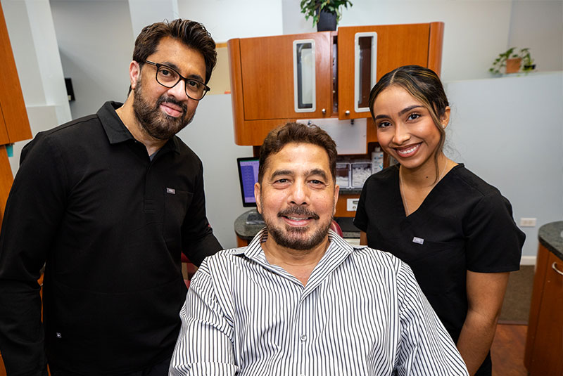 full mouth dental implant patient smiling with Dr. Asim